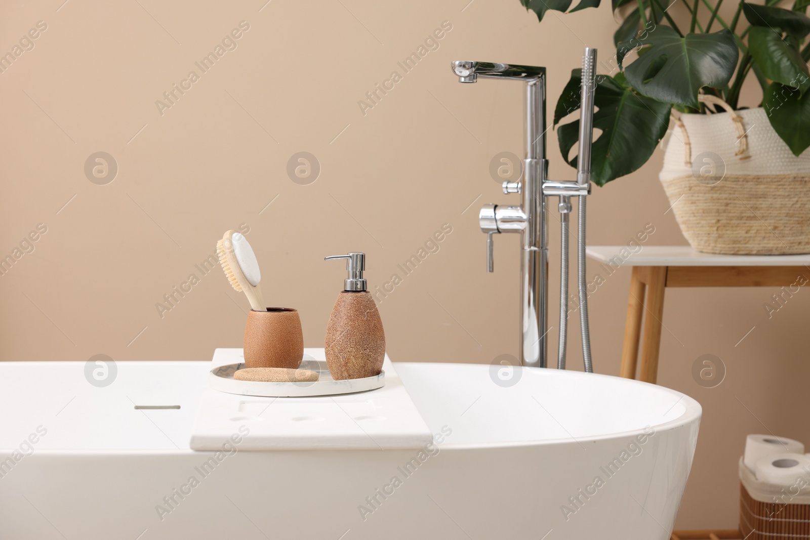 Photo of Different personal care products and accessories on bath tub in bathroom