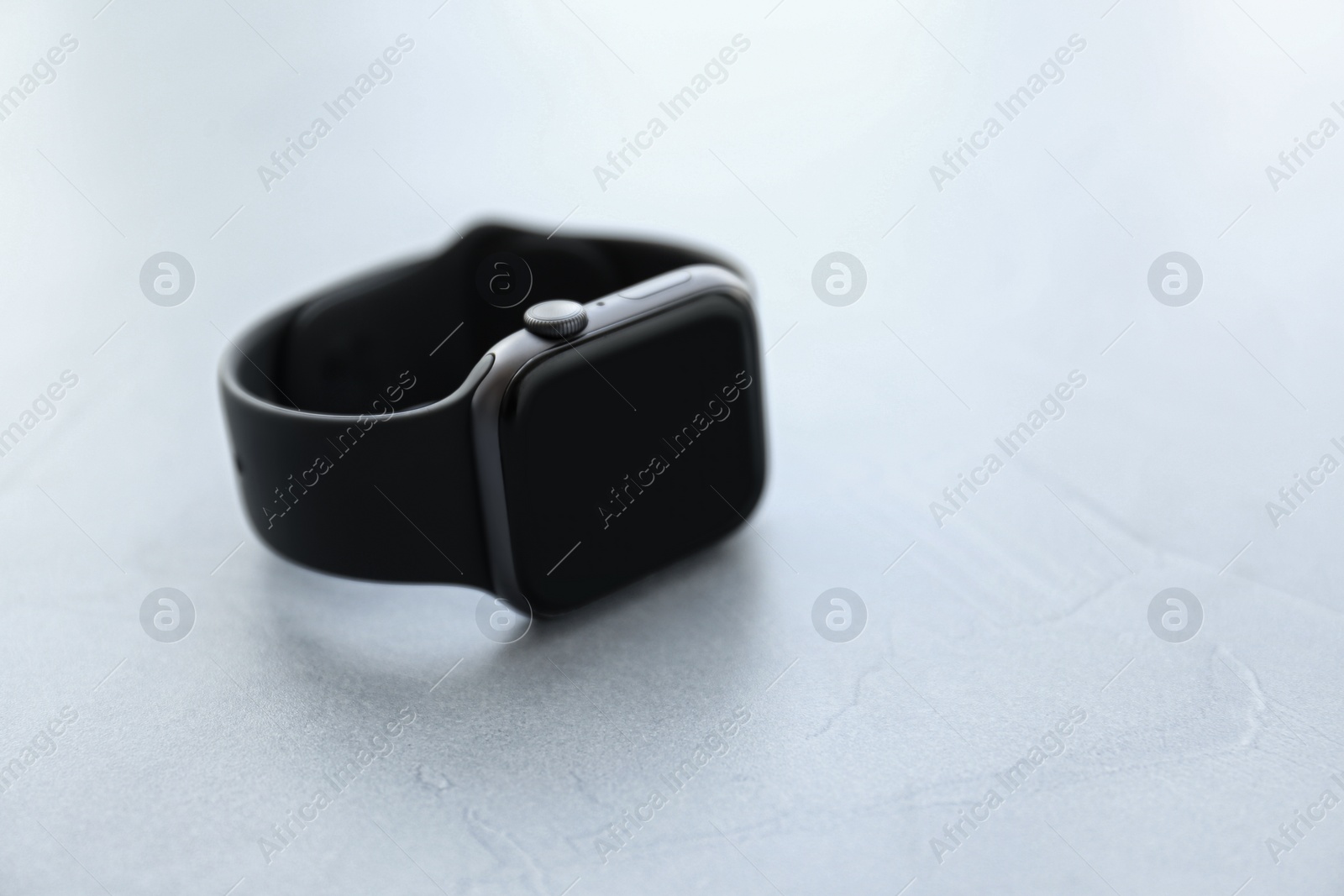 Stylish smart watch on grey stone table, closeup. Space for text Photo of Stylish smart watch on grey stone table, closeup. Space for text