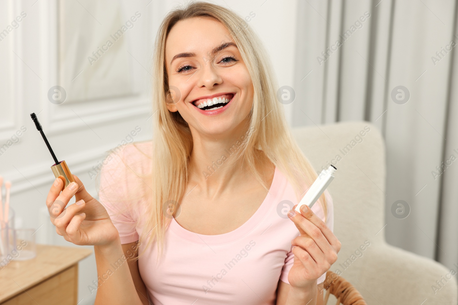 Photo of Beautiful happy woman with mascara at home