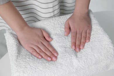 Photo of Woman touching soft white towel, closeup view