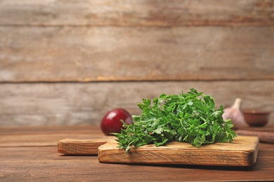 Photo of Board with fresh green parsley on table