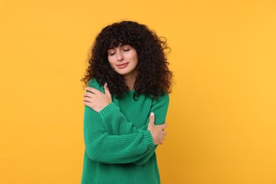 Photo of Young woman in stylish green sweater on yellow background