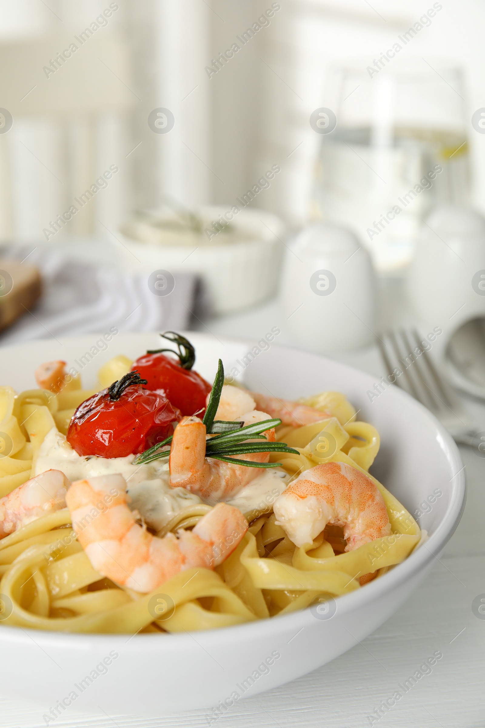 Photo of Delicious pasta with shrimps on white wooden table, closeup