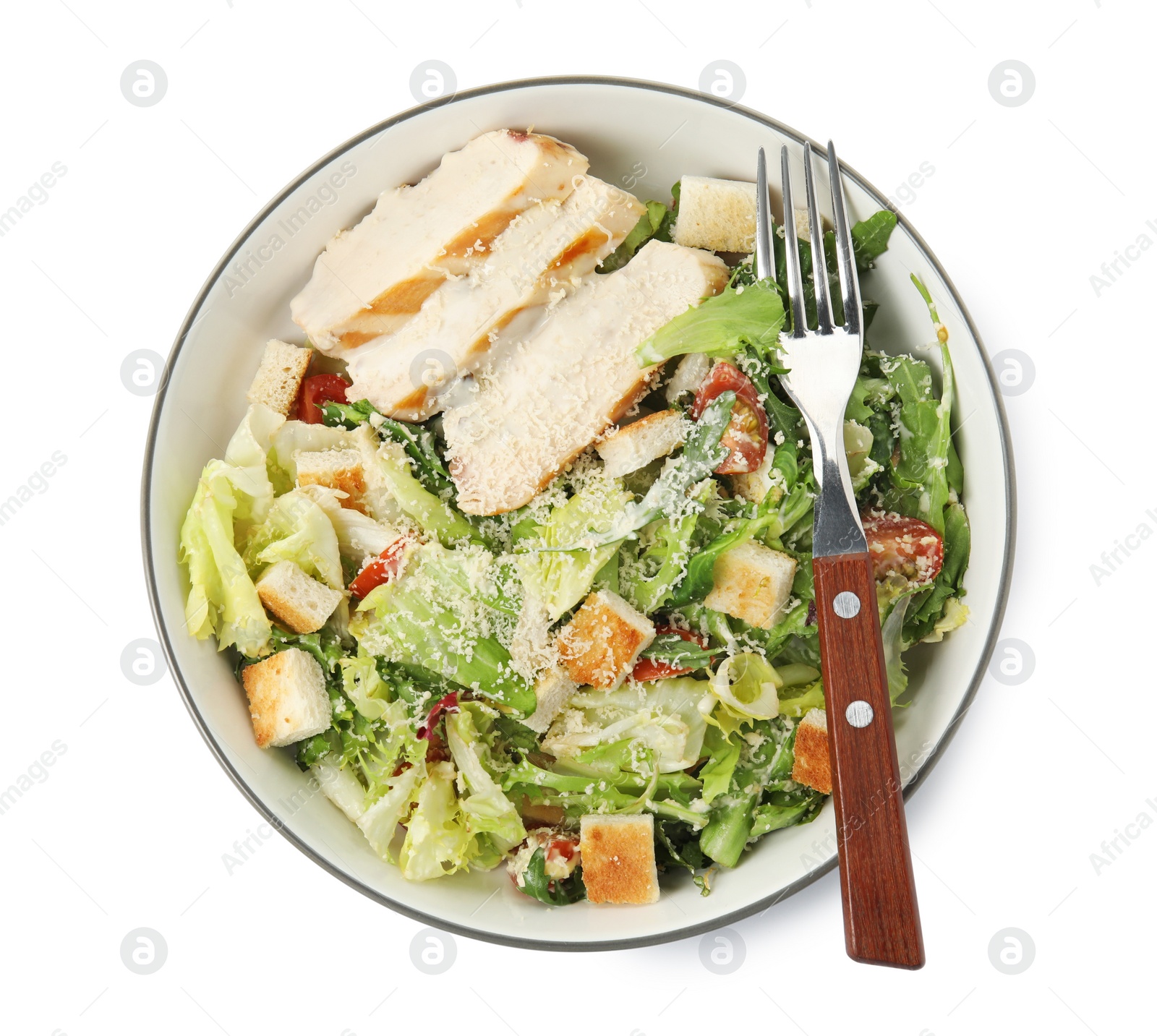 Photo of Delicious Caesar salad in bowl isolated on white, top view