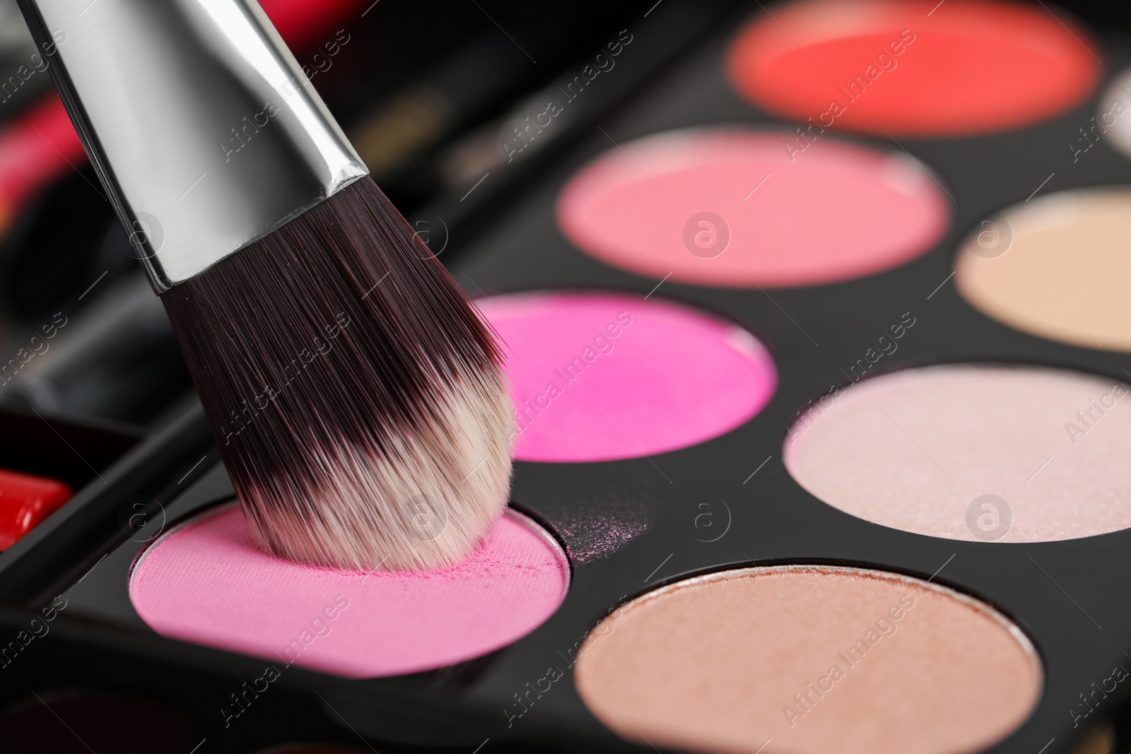 Photo of Colorful eyeshadow palette with brush, closeup view