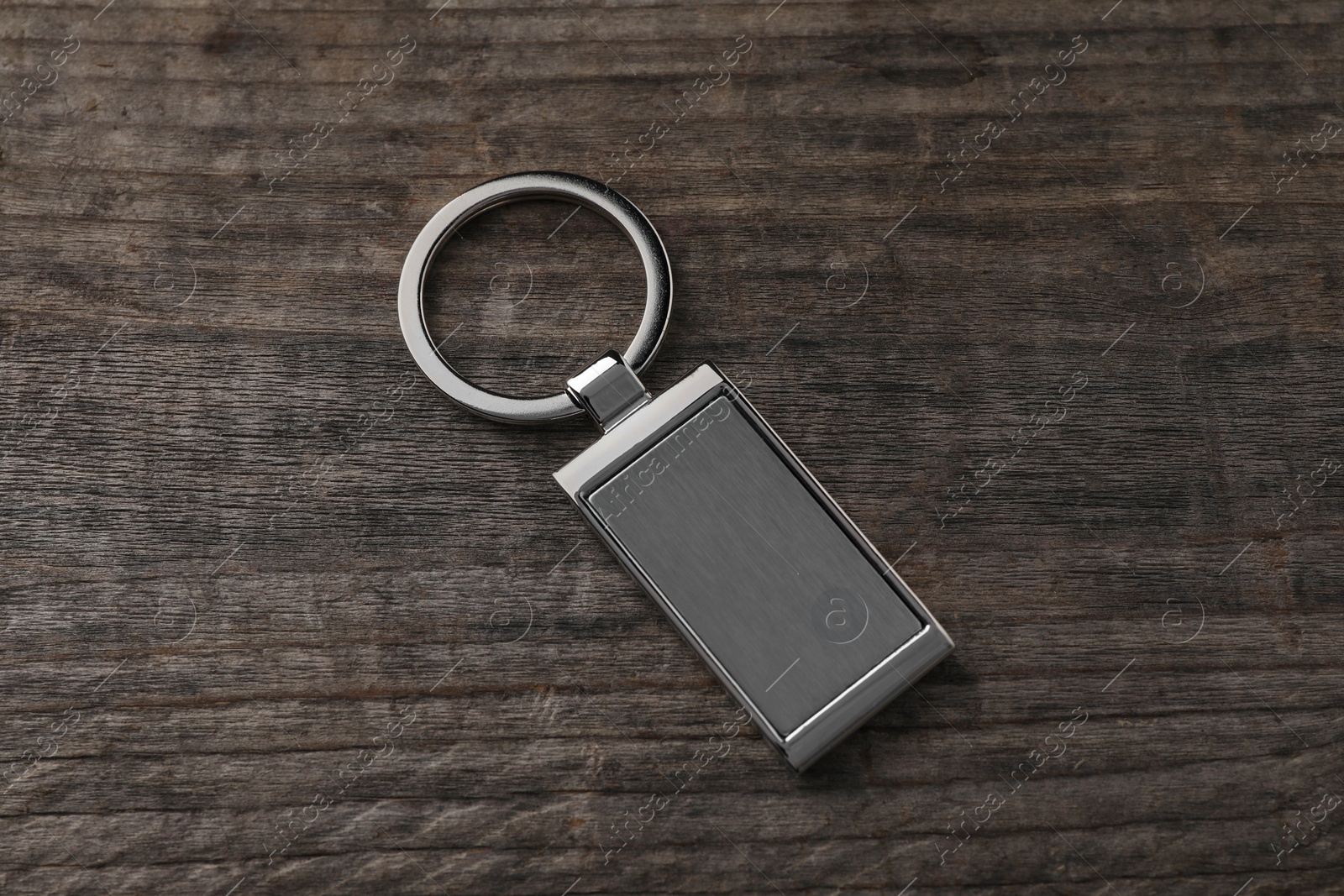 Photo of Metallic keychain on wooden background, above view