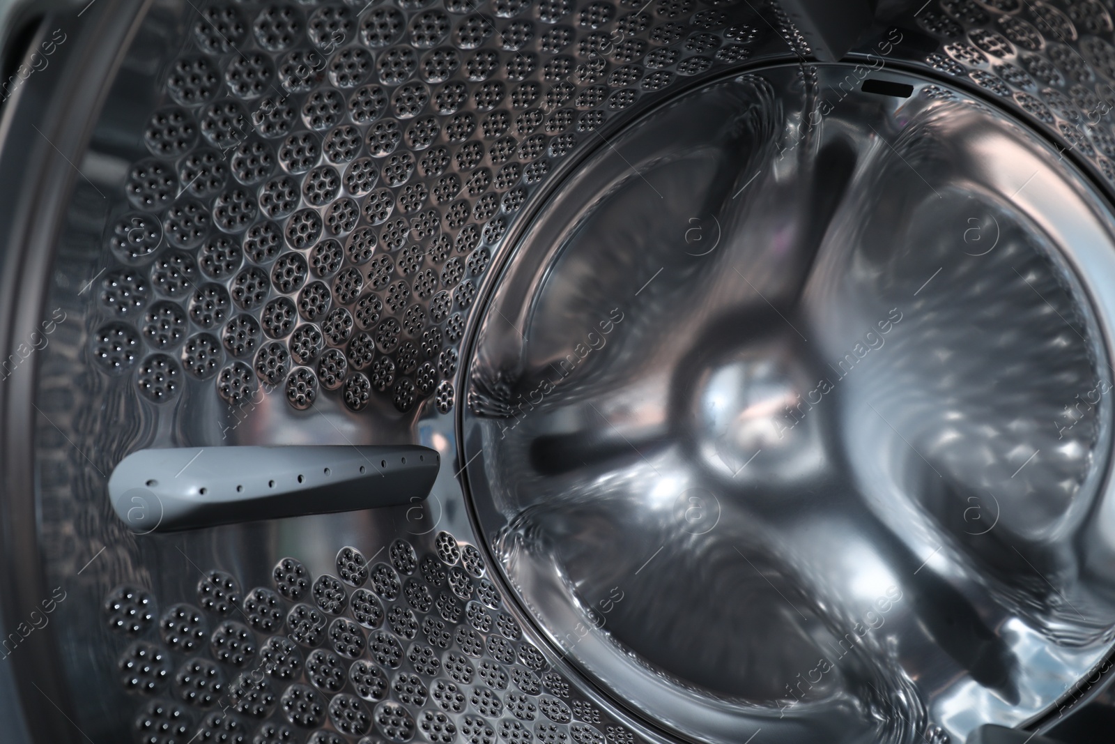 Photo of Empty washing machine drum, closeup. Laundry day