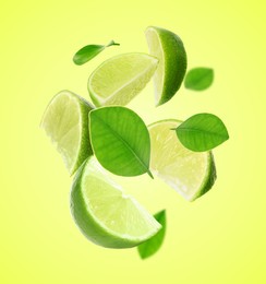 Image of Fresh lime slices and leaves falling on green yellow background