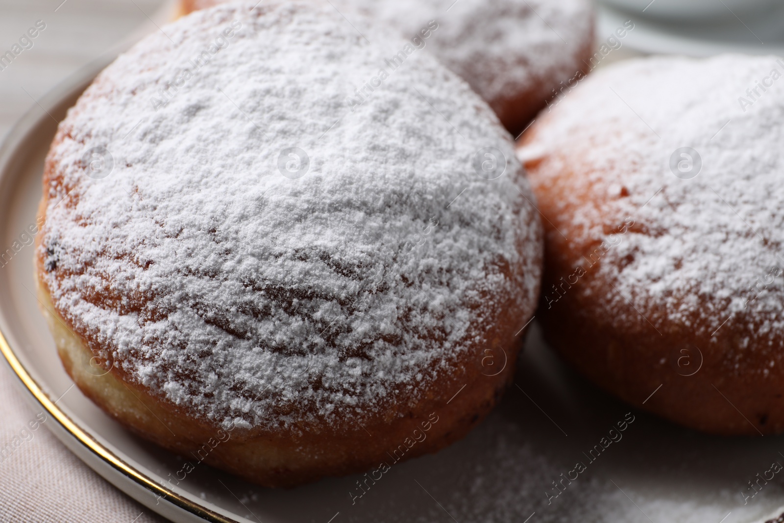 Photo of Delicious sweet buns with powdered sugar on table, closeup