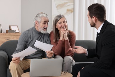 Photo of Insurance agent consulting elderly couple about pension plan in room