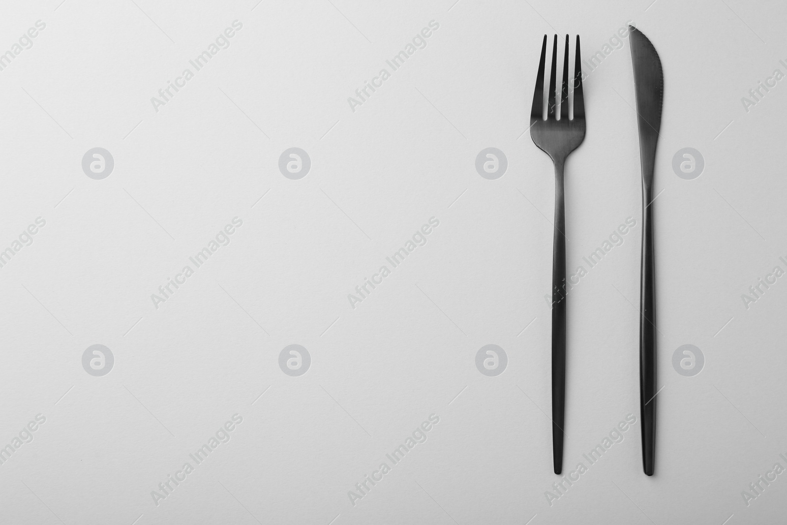 Photo of Stylish cutlery on grey table, top view. Space for text