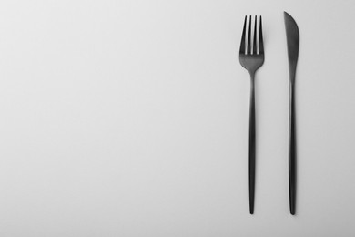 Photo of Stylish cutlery on grey table, top view. Space for text