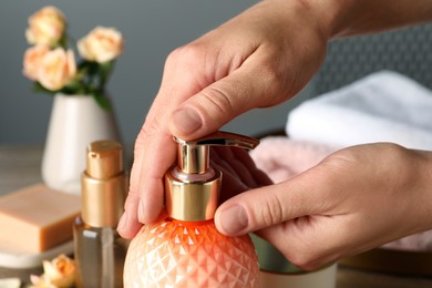 Photo of Woman using liquid soap dispenser, closeup view