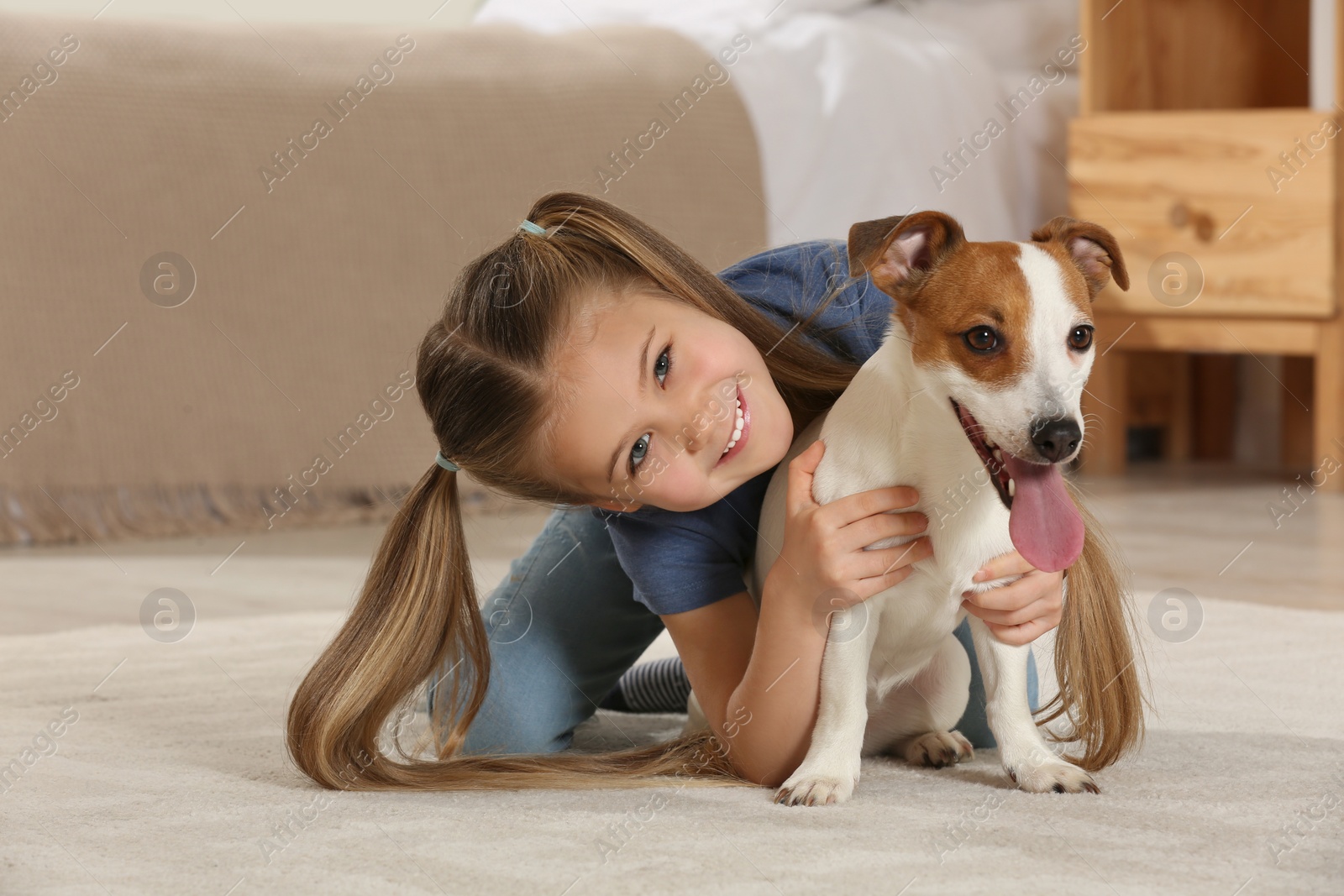 Photo of Cute girl with her dog on floor at home. Adorable pet