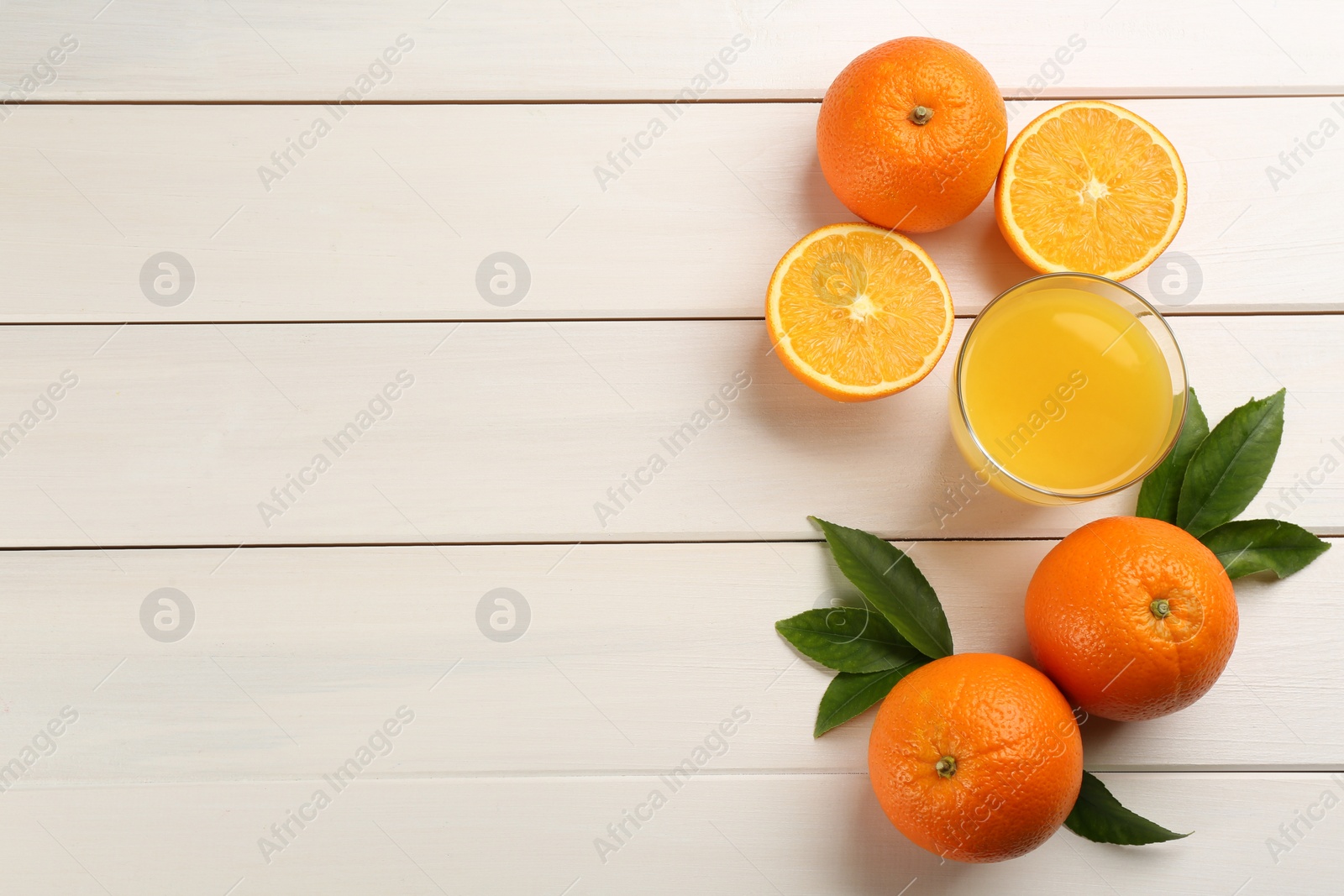 Photo of Delicious orange juice and fresh fruits on white wooden table, flat lay. Space for text