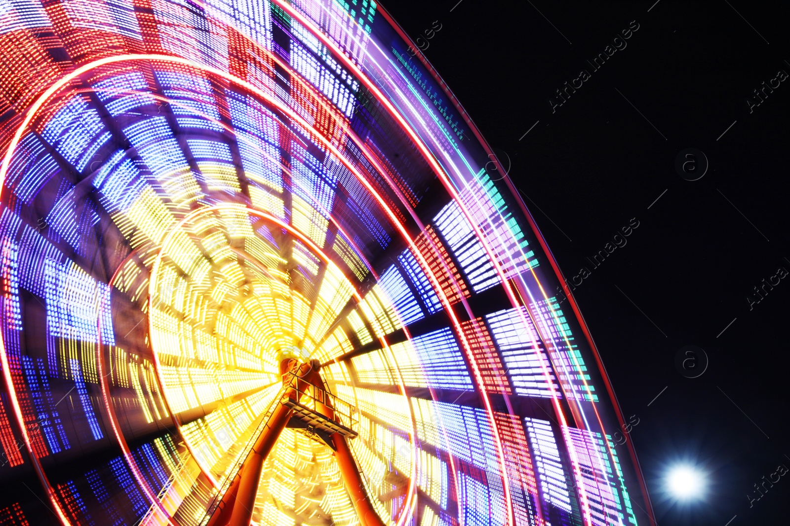 Photo of Beautiful glowing Ferris wheel against dark sky, low angle view. Space for text