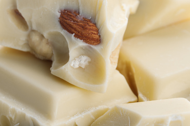 Pieces of white chocolate with nuts as background, closeup