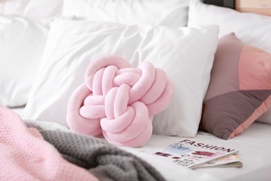 Photo of Pillows and magazines on bed. Idea for interior design