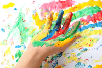 Photo of Child with painted palm on color background, closeup