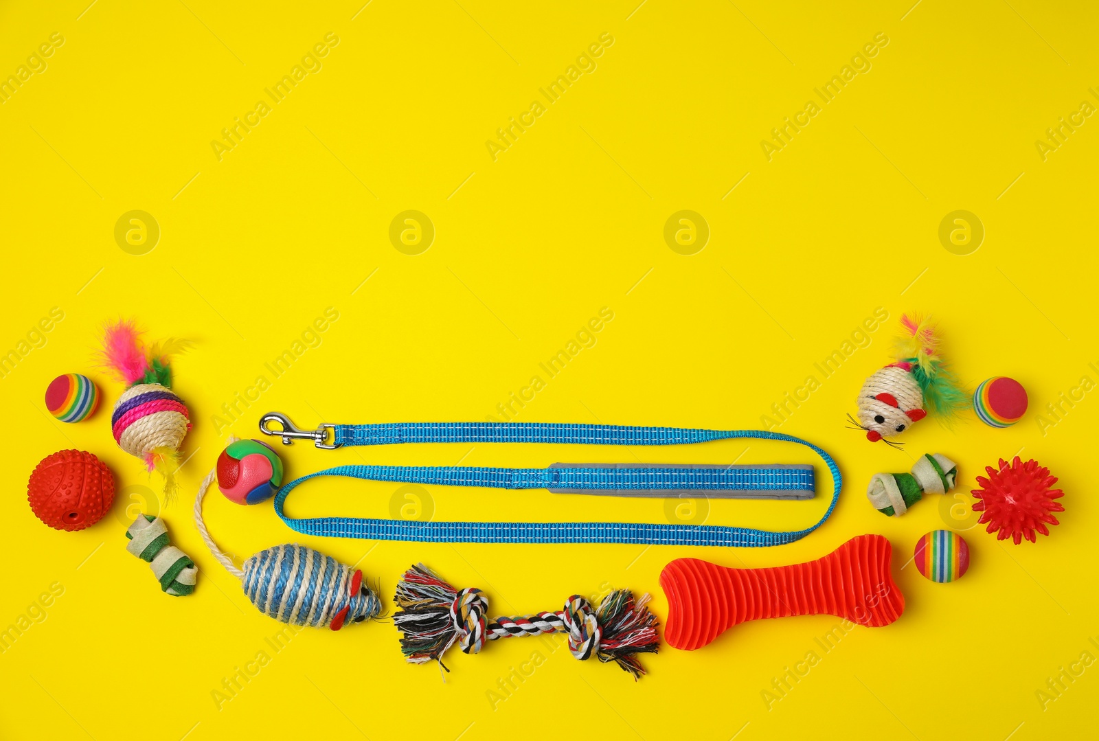Photo of Flat lay composition with pet leash and toys on yellow background, space for text