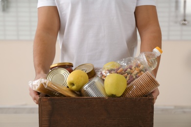 Photo of Man holding donation box with food, closeup
