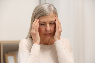 Photo of Menopause. Woman suffering from headache at home