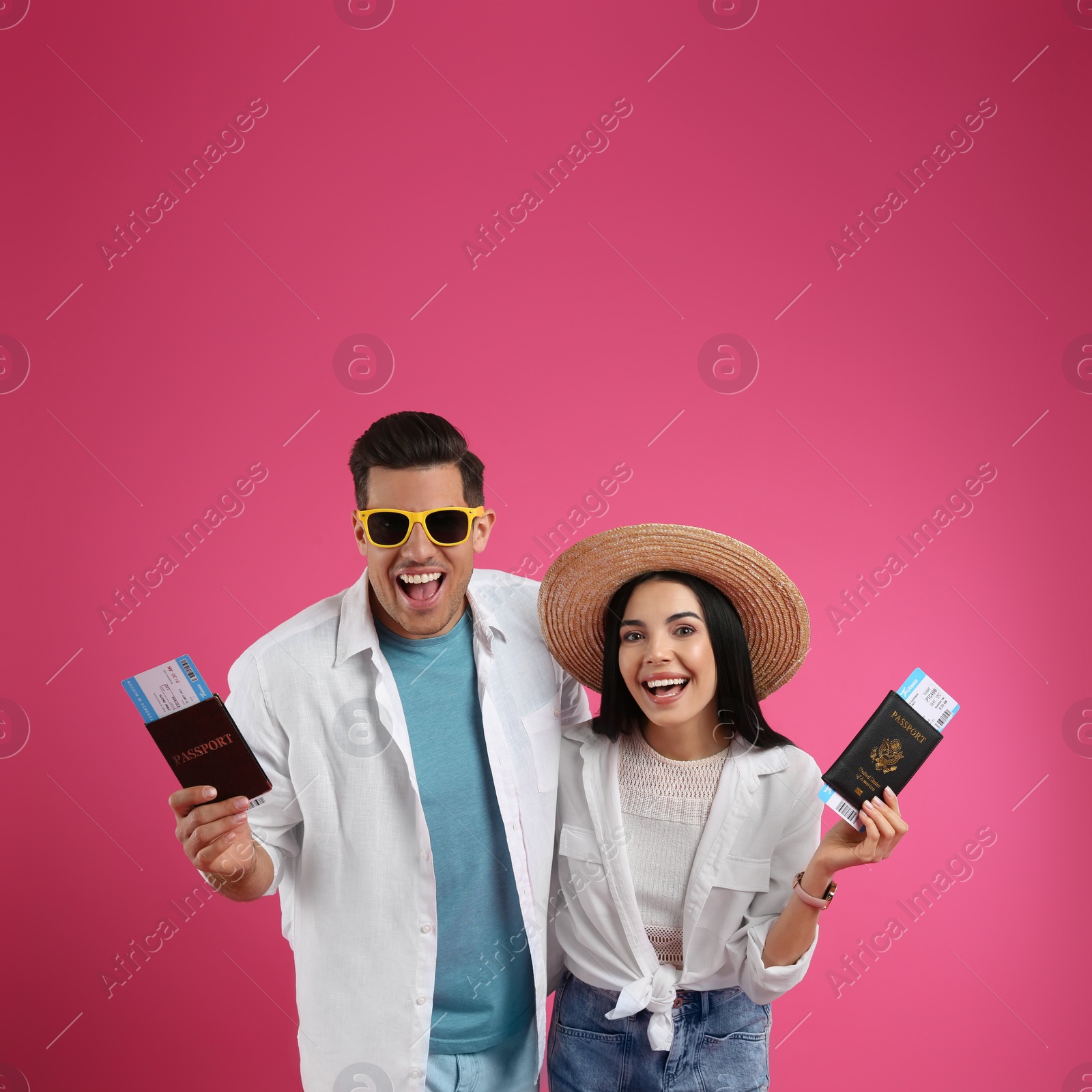 Photo of Couple of tourists with tickets and passports on pink background