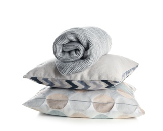 Photo of Stylish soft pillows and rolled plaid on white background