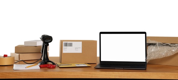 Photo of Parcels, laptop and barcode scanner on wooden table against white background. Online store