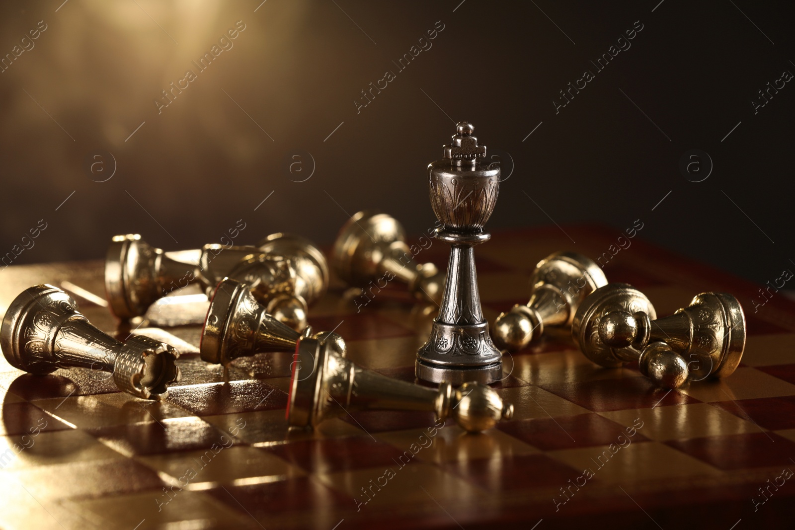 Photo of Chessboard with game pieces on dark background, closeup