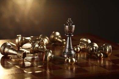 Photo of Chessboard with game pieces on dark background, closeup