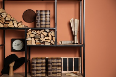 Photo of Stylish shelving unit with decorative elements near color wall. Interior design