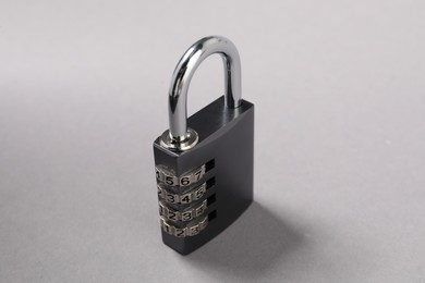 Photo of One steel combination padlock on grey background, closeup
