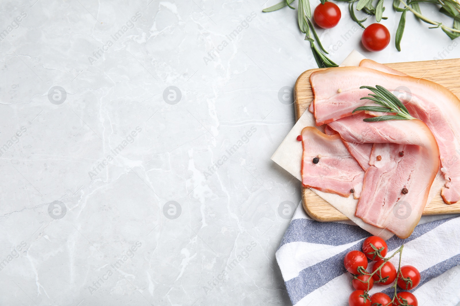 Photo of Flat lay composition with sliced raw bacon on light grey marble table. Space for text