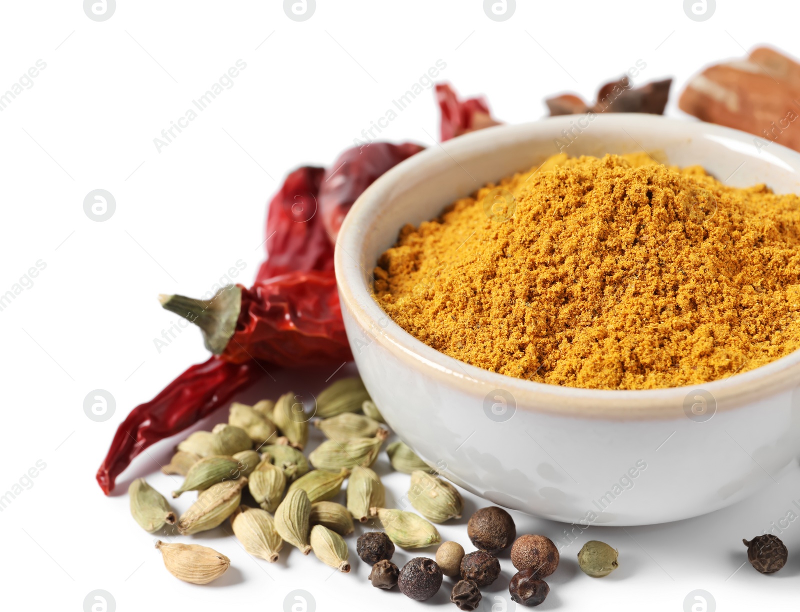 Photo of Curry powder in bowl and other spices isolated on white