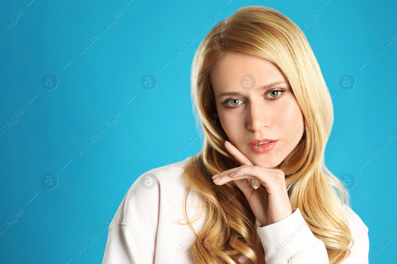 Photo of Portrait of beautiful young woman with dyed long hair on blue background