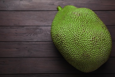Photo of Fresh exotic jackfruit on black wooden table, top view. Space for text