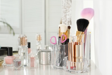 Photo of Luxury makeup products and accessories on dressing table with mirror. Space for text