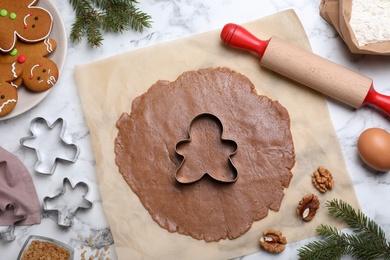 Photo of Making homemade gingerbread man cookies on white marble table, flat lay