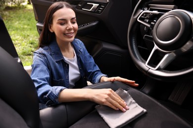 Photo of Woman wiping her modern car with rag