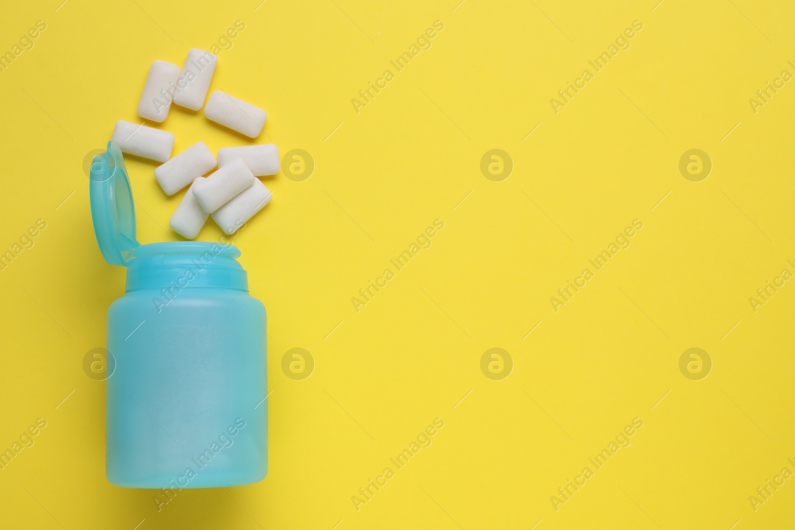 Photo of Jar with chewing gums on yellow background, flat lay. Space for text