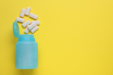 Jar with chewing gums on yellow background, flat lay. Space for text