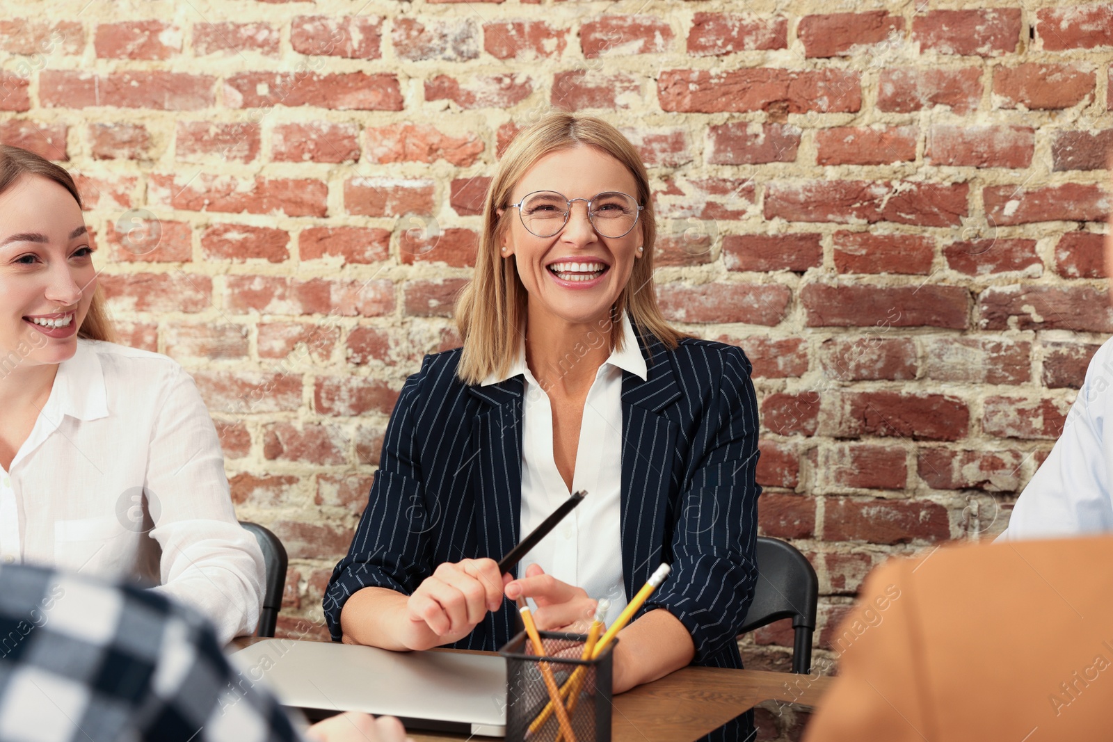 Photo of Businesswoman having meeting with her employees in office. Lady boss