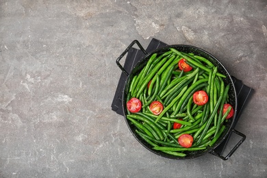 Photo of Dish with tasty green beans and tomatoes on table, top view