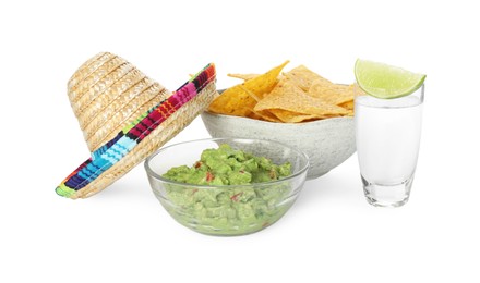 Photo of Mexican sombrero hat, tequila with lime, nachos chips and guacamole in bowls isolated on white