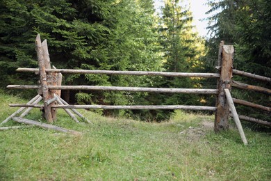 Photo of Old wooden fence near conifer forest outdoors