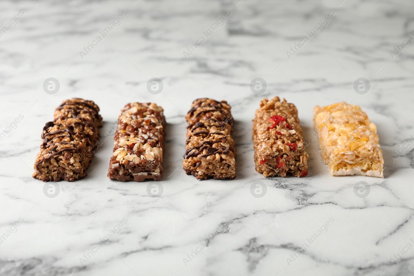 Photo of Tasty protein bars on marble table. Healthy snack