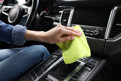 Photo of Woman wiping her modern car with rag, closeup