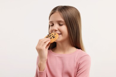 Photo of Cute girl with chocolate chip cookie on white background
