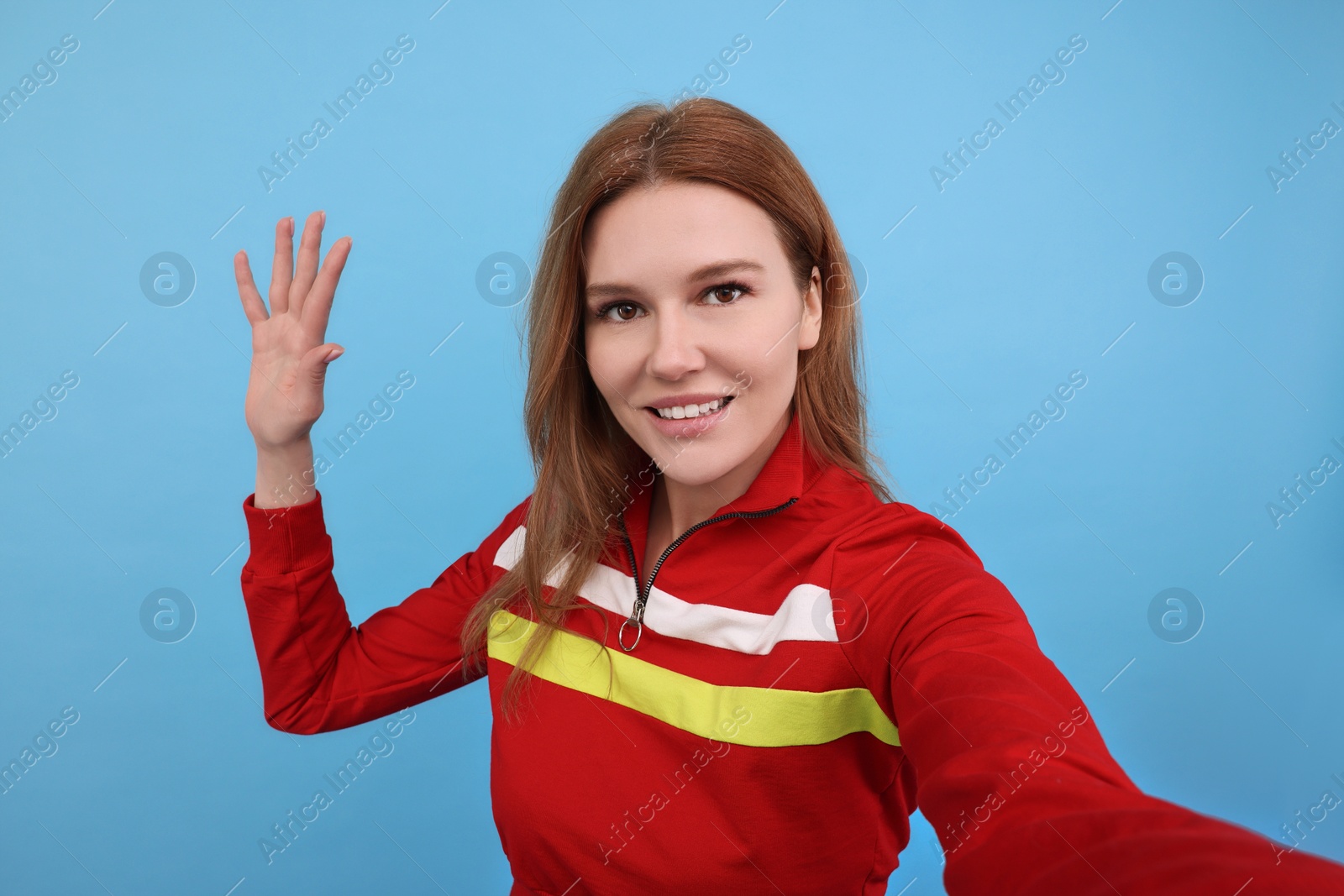 Photo of Beautiful woman taking selfie on light blue background